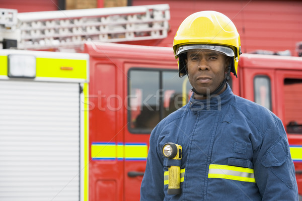 Portrait of a firefighter standing in front of a fire engine Stock photo © monkey_business