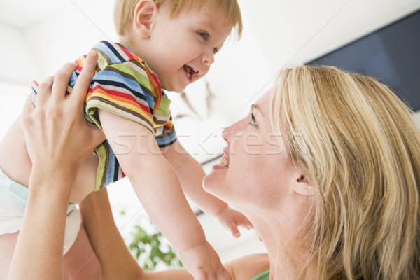Mother in living room holding baby smiling Stock photo © monkey_business