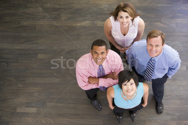 Vier Geschäftsleute stehen drinnen lächelnd Business Stock foto © monkey_business