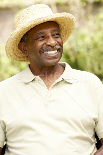 Zdjęcia stock: Uśmiechnięty · starszy · człowiek · ogród · hat · osoby