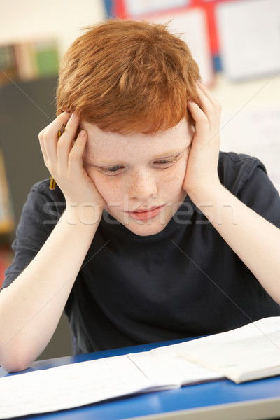 Stock photo: Stressed Schoolboy Studying In Classroom