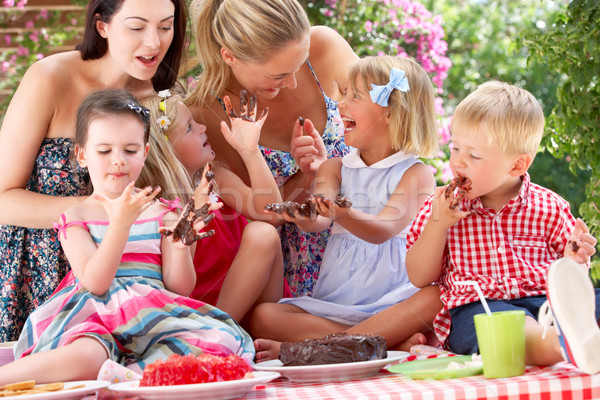 Enfants mères manger gelée gâteau extérieur Photo stock © monkey_business