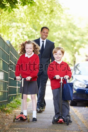 A woman with a pushchair walking her son home from school Stock photo © monkey_business