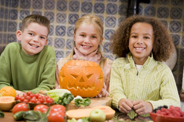 Three young friends on Halloween with jack o lantern and food sm Stock photo © monkey_business