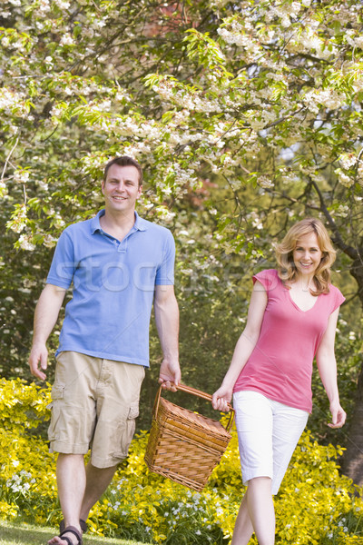 Pareja caminando aire libre cesta de picnic sonriendo primavera Foto stock © monkey_business