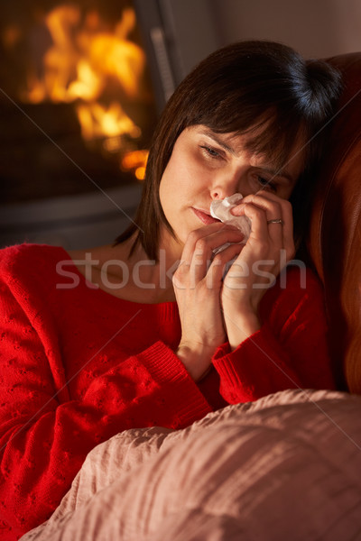 Sick Woman With Cold Resting On Sofa By Cosy Log Fire Stock photo © monkey_business