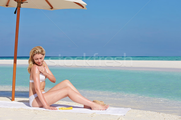 Woman Applying Sun Lotion On Beach Holiday Stock photo © monkey_business