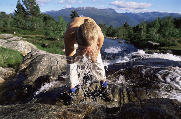 Stock photo: Young woman washing face in river