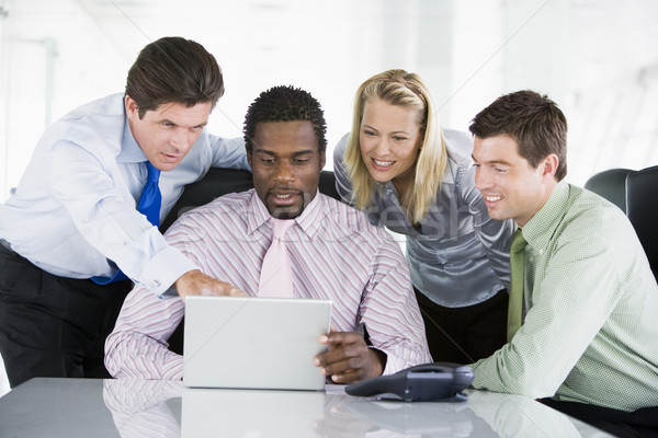 Four businesspeople in a boardroom pointing at laptop and smilin Stock photo © monkey_business