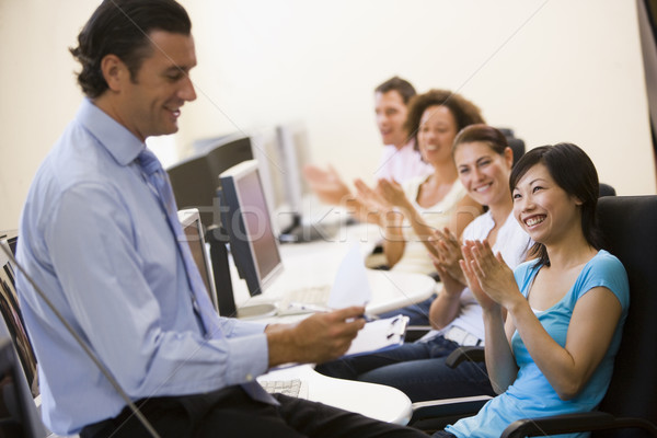 Man with clipboard giving lecture in applauding computer class Stock photo © monkey_business