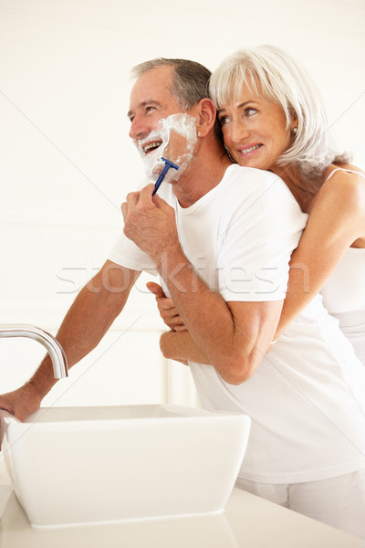 Senior Man Shaving In Bathroom Mirror With Wife Watching Stock photo © monkey_business