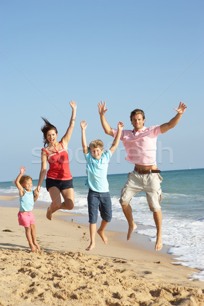 Portrait Of Family On Beach Holiday Jumping In Air Stock photo © monkey_business