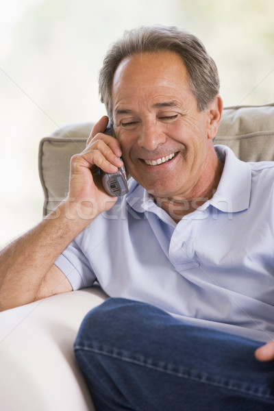 Stock photo: Man indoors using telephone smiling