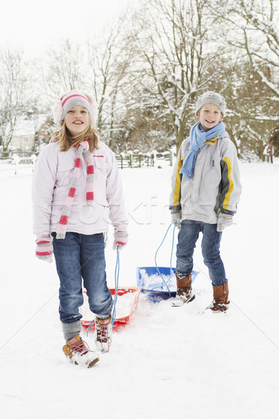 Children Pulling Sledge Through Snowy Landscape Stock photo © monkey_business