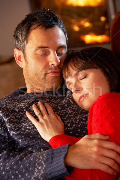 Middle Aged Couple Cuddling On Sofa By Cosy Log Fire Stock photo © monkey_business