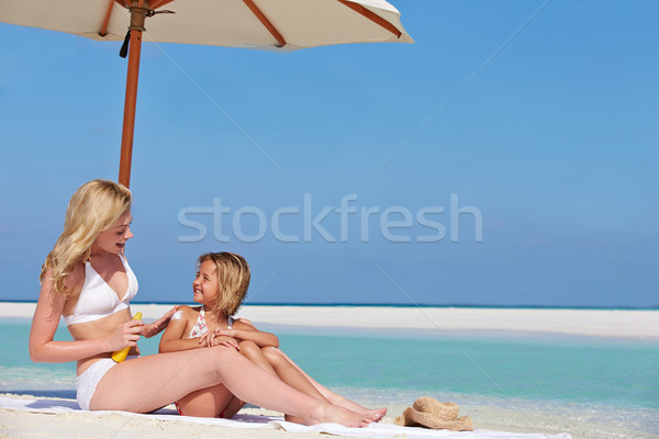 Mother Protecting Daughter With Sun Lotion On Beach Holiday Stock photo © monkey_business