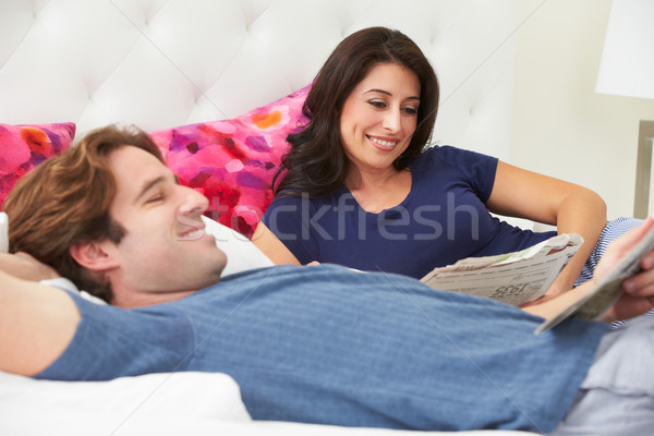 Couple Relaxing In Bed Wearing Pajamas And Reading Newspaper Stock photo © monkey_business