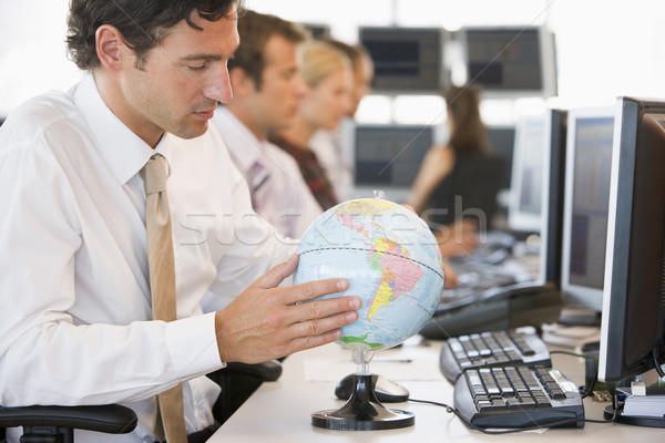 Businessman in office space with a desk globe Stock photo © monkey_business