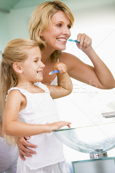 Woman and young girl in bathroom brushing teeth Stock photo © monkey_business