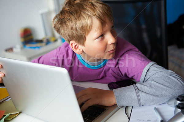 Boy Behaving Suspiciously Whilst Using Laptop Stock photo © monkey_business