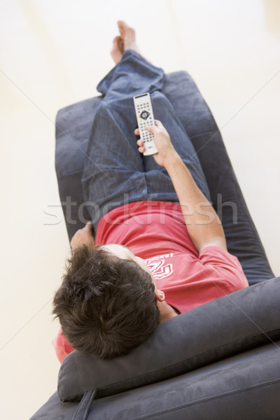 Man sitting in chair using remote control Stock photo © monkey_business