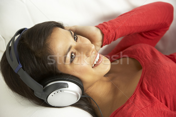 Stock photo: Young Woman Listening To Music At Home