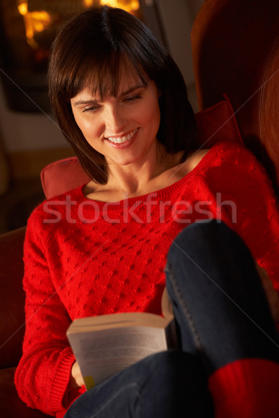 Middle Aged Woman Relaxing With Book By Cosy Log Fire Stock photo © monkey_business