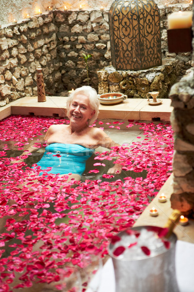 Senior Woman Relaxing In Flower Petal Covered Pool At Spa Stock photo © monkey_business