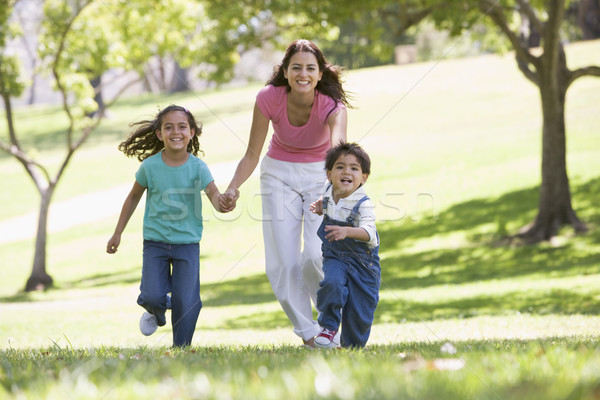 Woman with two young children running outdoors smiling Stock photo © monkey_business