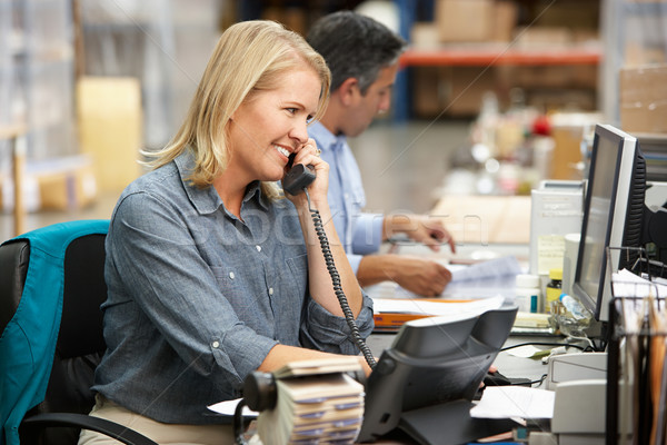 Stock photo: Businesswoman Working At Desk In Warehouse