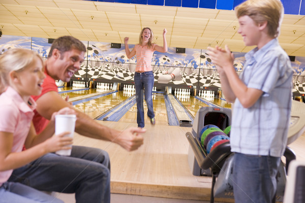 Family in bowling alley cheering and smiling Stock photo © monkey_business