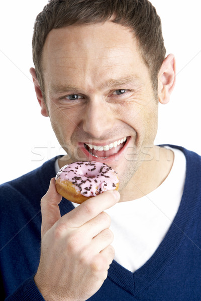 Homme mordre donut studio souriant Photo stock © monkey_business