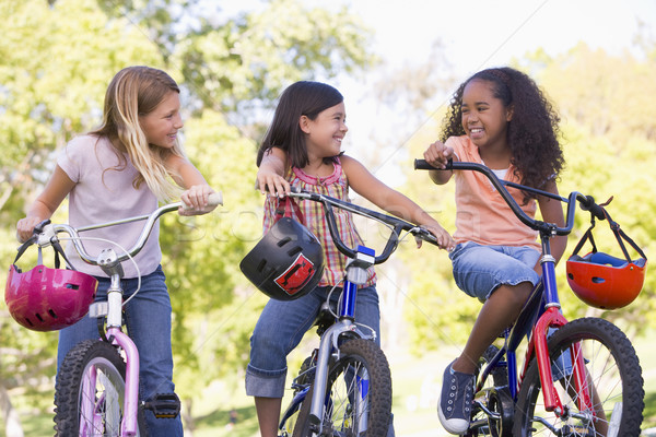 Három fiatal lány barátok kint biciklik mosolyog Stock fotó © monkey_business