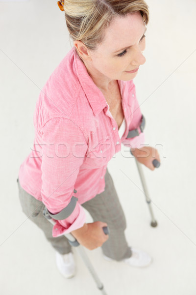 Stock photo: Woman walking with crutches