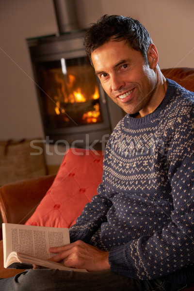 Middle Aged Man Relaxing With Book By Cosy Log Fire Stock photo © monkey_business