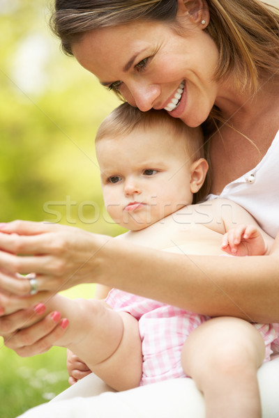 Mother Sitting With Baby Girl In Field Of Summer Flowers Stock photo © monkey_business