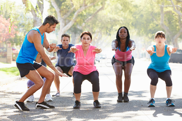 Stock photo: Group Of People Exercising Street With Personal Trainer