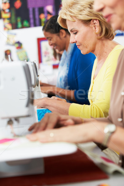 Stock photo: Group Of Women Using Electric Sewing Machines In class