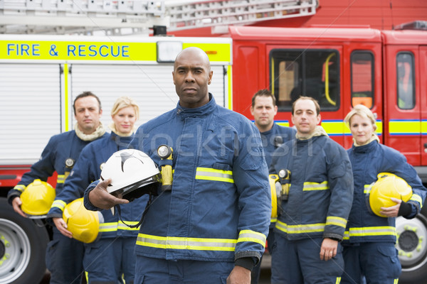 Stock photo: Portrait of a group of firefighters by a fire engine