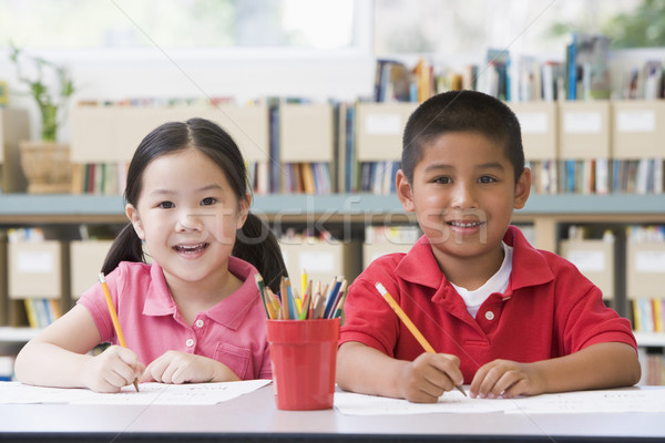 Kindergarten children sitting at desk and writing in classroom Stock photo © monkey_business