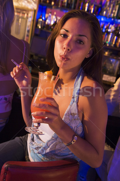 Young woman drinking and smoking at a bar Stock photo © monkey_business