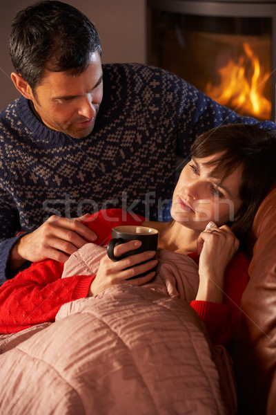 Husband Nursing Sick Wife With Cold Resting On Sofa By Cosy Log  Stock photo © monkey_business