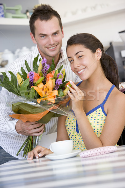 A young man giving flowers to a young woman in a cafe Stock photo © monkey_business