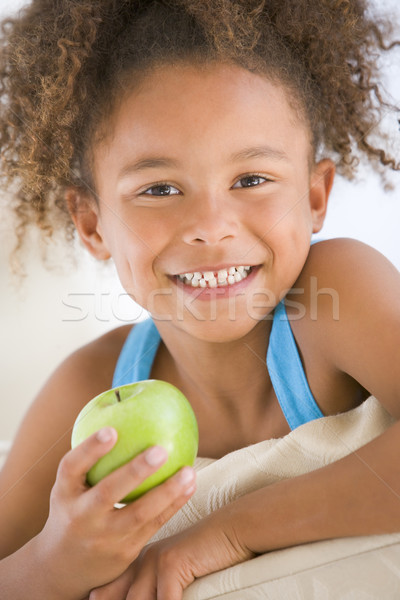 Young girl eating apple in living room smiling Stock photo © monkey_business