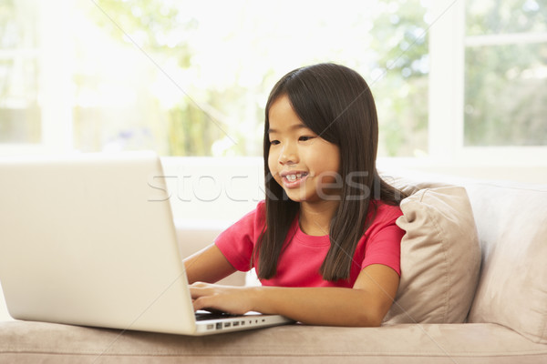 Młoda dziewczyna za pomocą laptopa domu szczęśliwy dziecko laptop Zdjęcia stock © monkey_business
