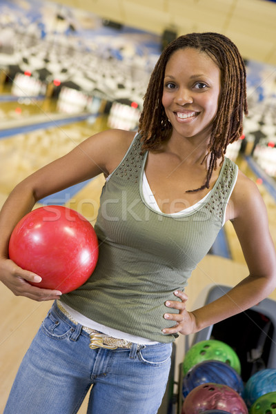 Young woman holding a bowling ball in a bowling alley Stock photo © monkey_business
