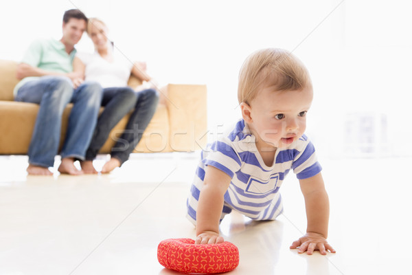 Stock photo: Couple in living room with baby smiling