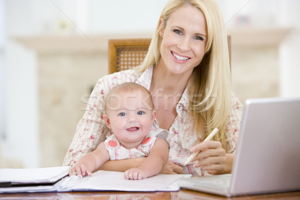 Mother and baby in dining room with laptop smiling Stock photo © monkey_business