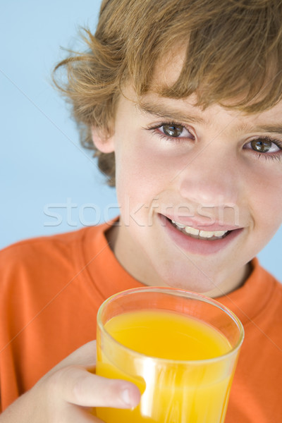 Stock photo: Young boy with glass of orange juice smiling