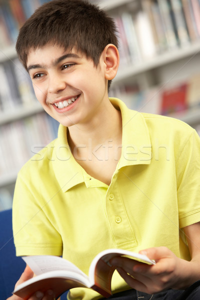 Masculino adolescente estudante biblioteca leitura livro Foto stock © monkey_business